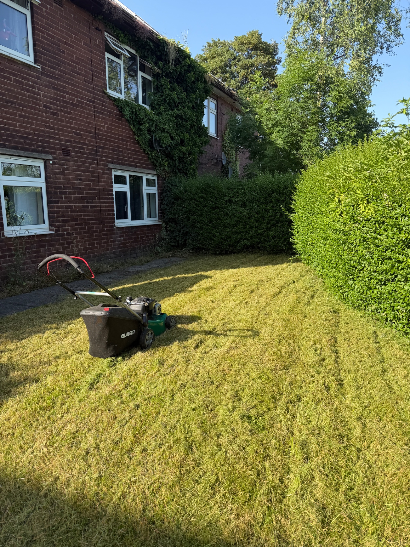 Front garden after grass cut and tidy with mower on lawn